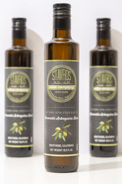 Set of 3 Stavros Koroneiki Arbequina Blend Extra Virgin Olive Oil bottle photographed, with one in focus, and the other two out of focus