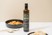 Bottle of Stavros Olive Oil with pasta on a white surface